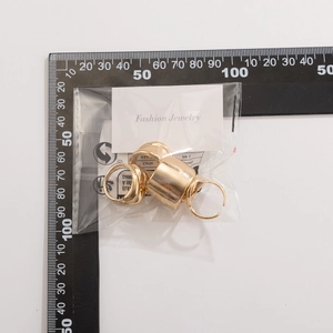 Irregular geometric gold ring set shown against a ruler for size measurement and scale