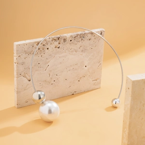 Detail of asymmetric choker with faux pearl and polished silver beads on stone