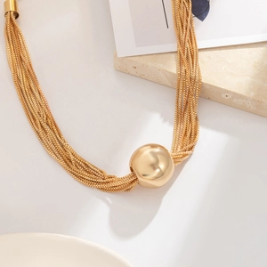 Collier multicouche doré avec grand pendentif perle polie au style chic et moderne