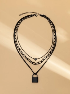 Close-up of triple-layered matte black necklace with heart and padlock pendant charms