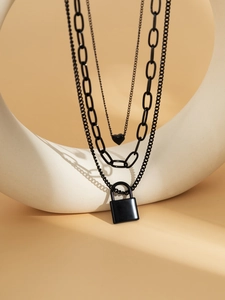Detailed view of layered black necklace featuring heart and lock pendants on metal chains