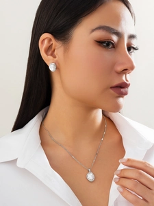 Détail d'un ensemble de bijoux en perles argentées avec collier et boucles d'oreilles