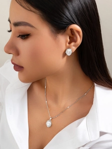 Détail de l'ensemble de bijoux minimaliste en perles avec collier et boucles sur un modèle