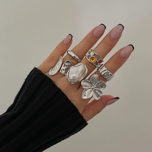 Detailed close-up of a vintage silver ring set with floral and pearl designs