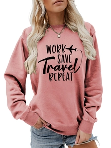 Close-up of pink crewneck sweatshirt featuring black Work Save Travel print and airplane icon