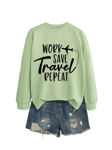 Flat lay of a mint green sweatshirt with 'Work Save Travel Repeat' text and denim shorts