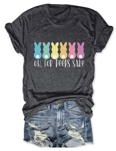 Flat lay of a grey T-shirt with bunny print and slogan next to distressed denim shorts