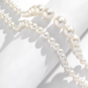 Detail of multi-layered white pearl necklaces showing different bead sizes and soft luster
