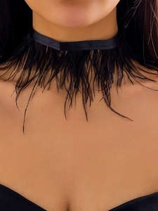 Gros plan d'un collier ras du cou en plumes noires élégantes avec ruban de velours