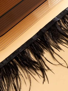 Vue macro de bordure en plumes d'autruche noires et ruban tissé pour collier chocker