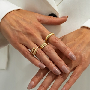 Detailed view of layered golden rings set including teardrop and dome design styles