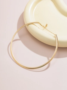 Gros plan détaillé d'un collier ras du cou doré poli avec chaîne ajustable et pendentif boule
