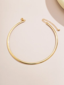 Détail d'un choker doré minimaliste avec fermoir mousqueton et chaîne d'extension réglable