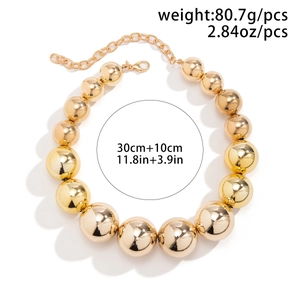 Détail d'un collier à grosses perles dorées avec fermoir mousqueton et chaîne de réglage