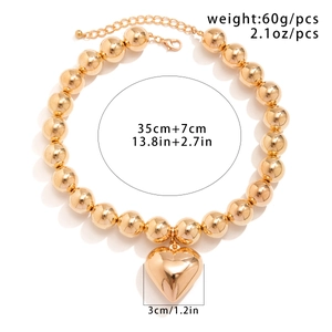 Chunky gold beaded necklace with a large polished heart pendant and adjustable chain