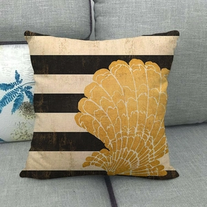 Detailed texture of yellow seashell print on striped linen pillowcase on a grey sofa