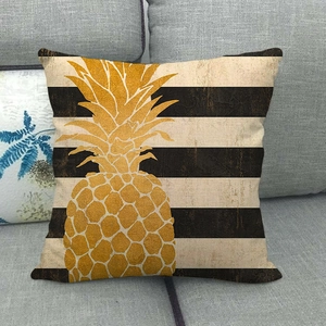 Detail of linen pillowcase featuring a golden pineapple over vintage striped fabric