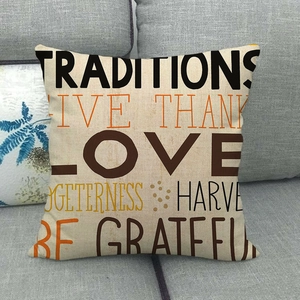 Close-up of linen pillow cover with fall harvest art text on a gray sofa