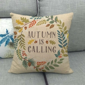 Detail of linen pillow cover on grey sofa with Autumn Is Calling wreath design