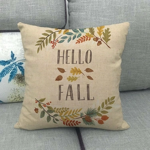 Detail of Hello Fall linen pillowcase with maple leaves and acorns on a grey sofa