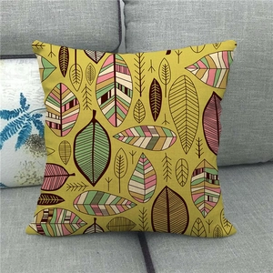 Close-up of artistic leaf pattern linen pillow cover on a modern grey fabric sofa