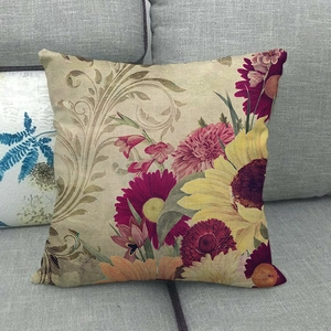 Close-up of rustic linen pillowcase featuring fall sunflowers on a gray sofa fabric