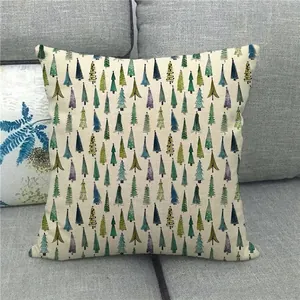 Close-up of linen pillowcase with colorful Christmas tree patterns on a grey sofa