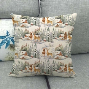 Detail of square linen pillow cover with vintage reindeer and snow scene on gray sofa