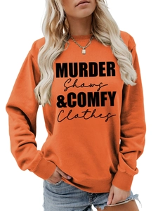 Detail of orange crewneck sweatshirt with black MURDER SHOWS & COMFY CLOTHES print