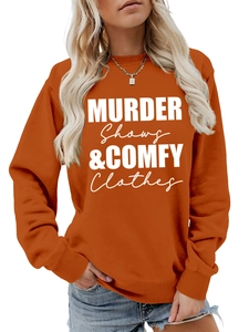 Detail of orange crewneck sweatshirt with 'Murder Shows & Comfy Clothes' slogan text