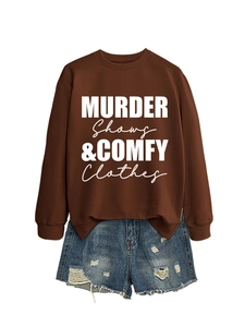 Flat lay of brown 'MURDER Shows & COMFY Clothes' sweatshirt with distressed denim shorts