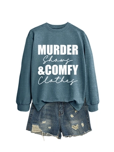 Detail of blue-grey sweatshirt with white lettering and distressed denim shorts with frayed edges