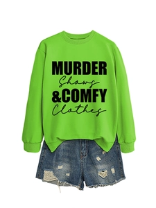 Detail of neon green crewneck sweatshirt with black MURDER SHOWS text and ripped denim shorts