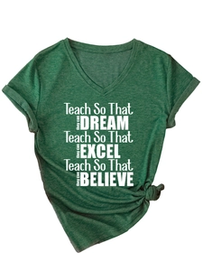 Détail des manches retroussées et du nœud décoratif sur le t-shirt vert col en V