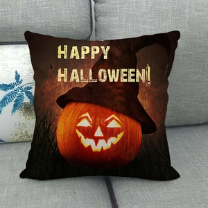 Détail de la housse de coussin citrouille Halloween avec chapeau sur un canapé en tissu