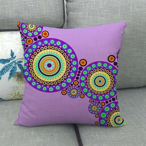 Detail of bohemian geometric mandala pattern on square linen pillowcase on a grey sofa
