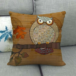 Close-up of retro owl linen pillowcase with autumn leaves on a grey sofa surface