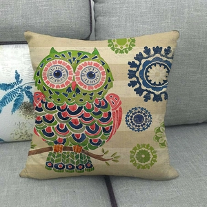 Cute cartoon owl linen throw pillow case on a grey fabric sofa with natural lighting