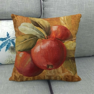Linen pumpkin fruit pillow cover with red apple painting on a grey fabric sofa