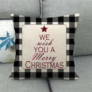 Detail of linen Christmas pillow cover with buffalo plaid pattern and festive lettering