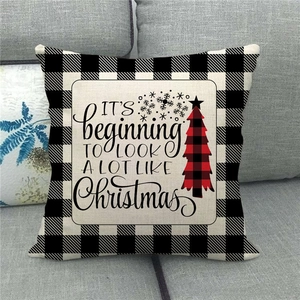 Close-up of Christmas linen pillowcase with black buffalo plaid and festive tree print
