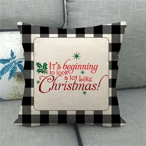 Macro detail of Christmas pillow cover with red festive text and buffalo plaid edges