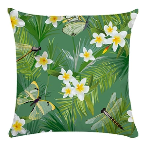 Detail of tropical throw pillow case with green palm leaves and white plumeria flowers