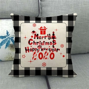 Merry Christmas linen pillowcase with black and white buffalo plaid border on grey sofa