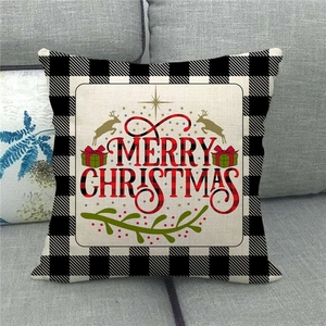 Close-up of Merry Christmas linen pillow cover with buffalo plaid border on a sofa