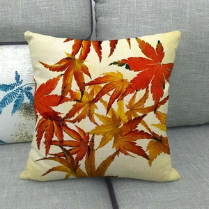 Detailed texture of linen pillow cover featuring autumn maple leaf print on sofa