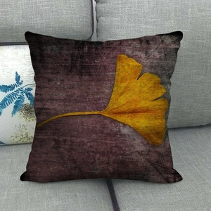 Detail of linen pillow cover with yellow ginkgo leaf design on vintage purple fabric