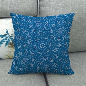 Detailaufnahme des geometrischen Mandala-Musters auf blauem Leinenkissen auf grauem Sofa