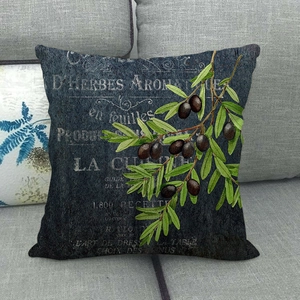 Detail of vintage linen pillow cover with botanical olive branch print on grey sofa