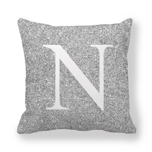 Dettaglio della texture glitterata e lettera N su una federa grigia quadrata